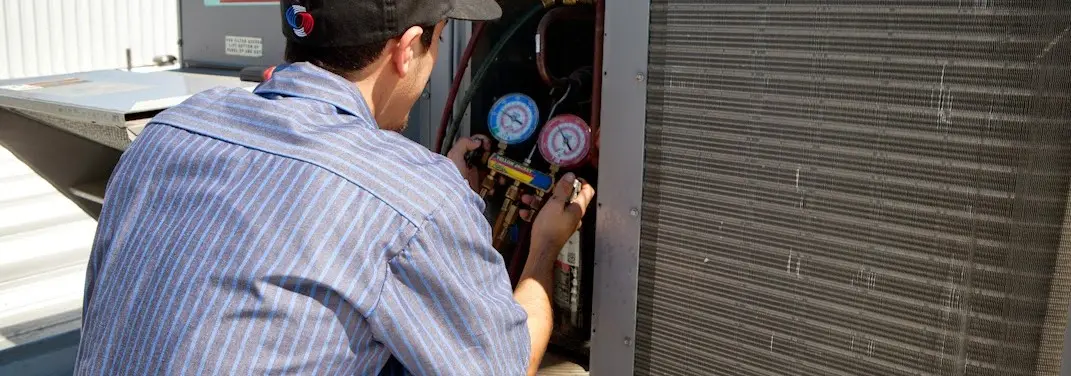 HVAC technician servicing a condenser unit in Bithlo
