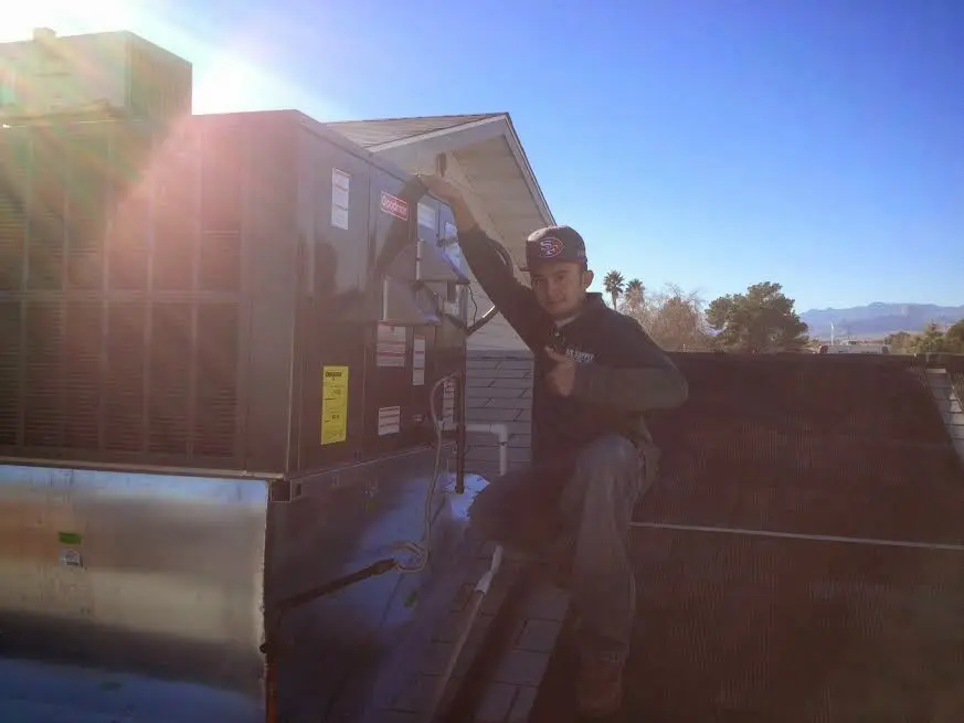 HVAC technician performing Air Duct Repair on a rooftop unit in Bithlo